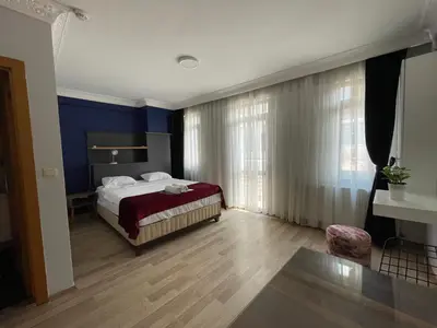 a bedroom with a bed with blue walls and wooden floors at Asteria House in Istanbul