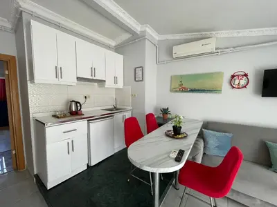 a kitchen and dining room with a table and red chairs at Asteria House in Istanbul