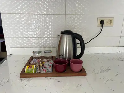 a coffee pot and cups on a wooden tray on a counter at Asteria House in Istanbul