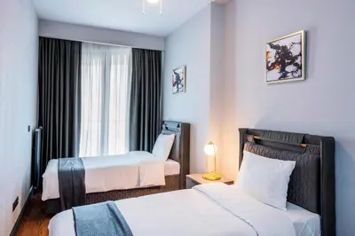 a hotel room with two beds and a window at Benesta Residence by NewInn in Istanbul
