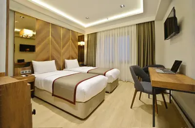 a hotel room with two beds and a desk at Celine Hotel Taxim in Istanbul