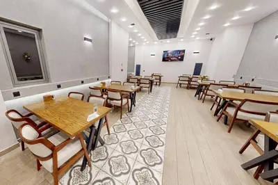 a dining room with wooden tables and chairs at King City Hotel Istanbul Ataturk Airport in Istanbul
