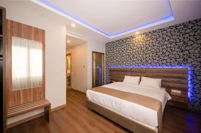 a bedroom with a large bed with a blue lighted wall at King City Hotel Istanbul Ataturk Airport in Istanbul
