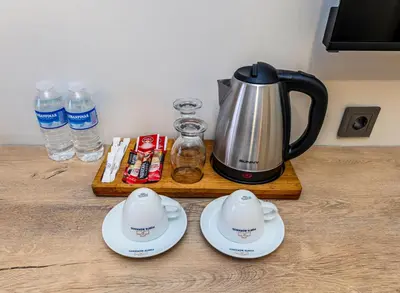 a coffee pot and saucers on a wooden table at Istanbul Old City Topkapi Porta Romanos Hotel Ottoman Heritage in Istanbul