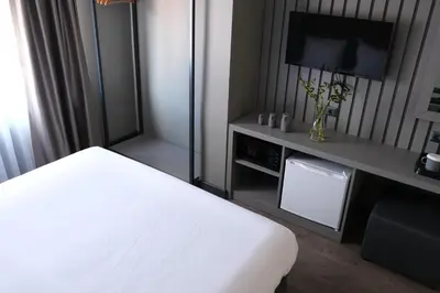 a hotel room with a white bed and a tv at Dilens Bosphorus Hotel in Istanbul