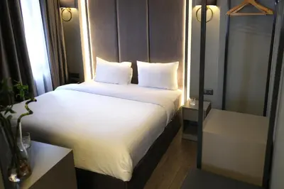 a bed with white sheets and pillows in a room at Dilens Bosphorus Hotel in Istanbul