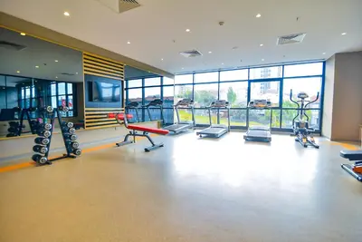 a gym with cardio equipment in a large room with windows at SERENİTY COMFORT Hotel in Istanbul