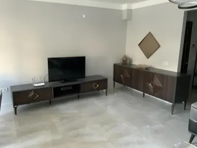 a living room with a flat screen tv on a cabinet at Luxury Z-Apart Family Homes 2 Bedrooms WIFI near Metro Zeytinburnu Istanbul in Istanbul