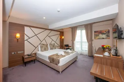 a hotel room with a large bed and a desk at Litros Hotel & Spa in Istanbul