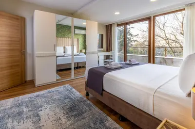 a bedroom with a large bed and a large window at BayMari Suites Plus Florya in Istanbul