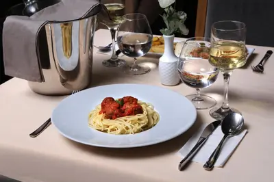 a plate of pasta with strawberries on a table with wine glasses at Stargate Hotel&Spa in Korfez