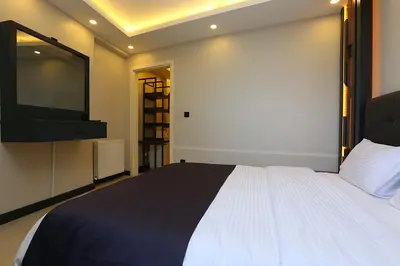 a bedroom with a bed and a flat screen tv at Galata King Suites in Istanbul