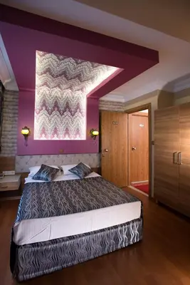 a bedroom with a large bed with a purple wall at Şirin Hotel in Istanbul