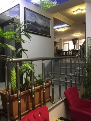 a room with a staircase with plants and red chairs at Şirin Hotel in Istanbul