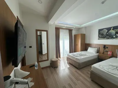 a hotel room with two beds and a flat screen tv at Hotel La SERA in Istanbul