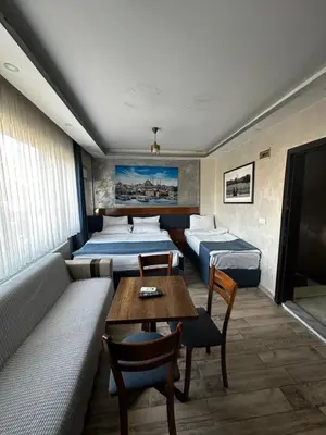 a room with beds and a table and a couch at yakut old hotel in Istanbul