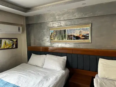 a bedroom with two beds and a painting on the wall at yakut old hotel in Istanbul