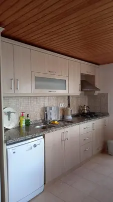 a kitchen with a white refrigerator and a white dishwasher at SNOW HİLL HOUSE Pansiyon in Kartepe
