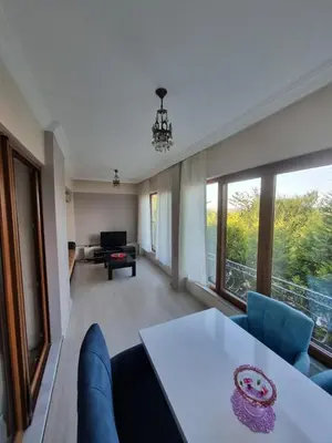 a living room with a table and blue chairs at SNOW HİLL HOUSE Pansiyon in Kartepe