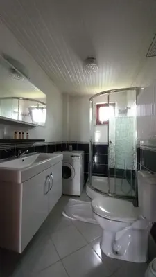 a bathroom with a toilet and a washing machine at SNOW HİLL HOUSE Pansiyon in Kartepe
