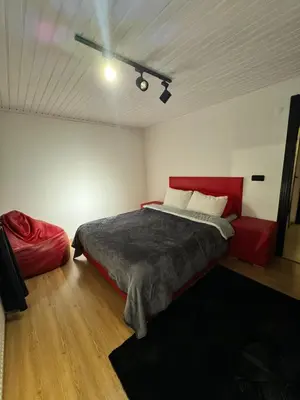 a bedroom with a red bed and a red couch at SNOW HİLL HOUSE Pansiyon in Kartepe