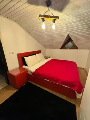 a bedroom with a red bed in a attic at SNOW HİLL HOUSE Pansiyon in Kartepe