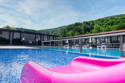 a large swimming pool with a pink slide in front of a building at Vela Verde Hotel & SPA in Yalova