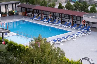 a swimming pool with lounge chairs and a hotel at Vela Verde Hotel & SPA in Yalova