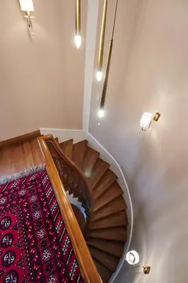 a wooden spiral staircase with a red carpet at White Palace Old City Boutique Hotel in Istanbul