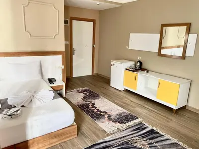 a bedroom with a white bed and a mirror at Airport Best Hotel in Istanbul