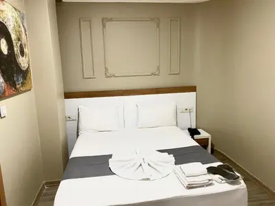 a bedroom with a white bed with towels on it at Airport Best Hotel in Istanbul
