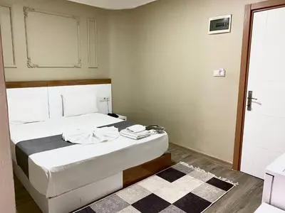a bedroom with a white bed with a black and white rug at Airport Best Hotel in Istanbul