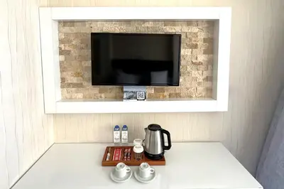 a coffee maker on a counter with a tv on a wall at Tekirdağ Yat Hotel in Tekirdag