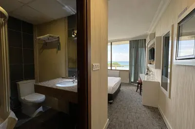 a bathroom with a sink and a toilet and a bed at Tekirdağ Yat Hotel in Tekirdag