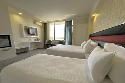 a hotel room with two beds and a television at Tekirdağ Yat Hotel in Tekirdag
