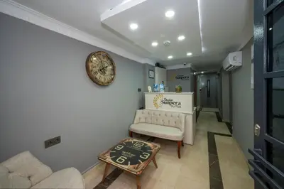 a living room with a couch and a clock on the wall at Taxim Sunpera Suites in Istanbul