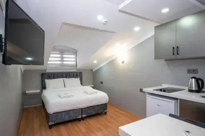 a small bedroom with a bed and a kitchen at Taxim Sunpera Suites in Istanbul
