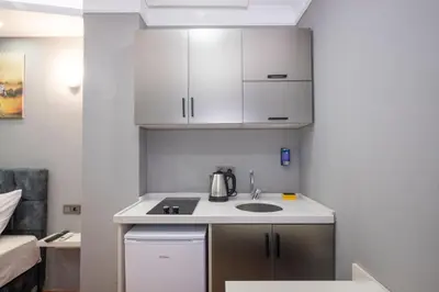 a small kitchen with a sink and white cabinets at Taxim Sunpera Suites in Istanbul