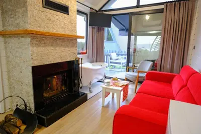 a living room with a red couch and a fireplace at World DREAMS Sapanca in Sakarya