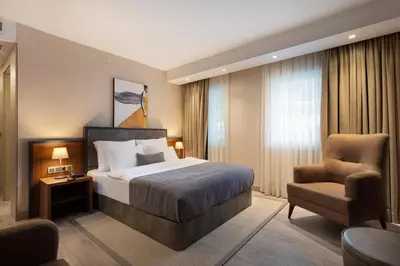 a hotel room with a bed and a chair at İzz Hotel Koşuyolu in Istanbul