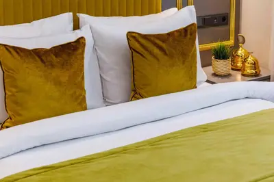 a bed with white and gold pillows on it at Santa Rio Taxim in Istanbul