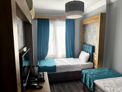 a small room with two beds and a window at Miss City Hotel Taksim in Istanbul