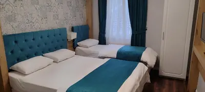 two beds in a room with blue and white at Miss City Hotel Taksim in Istanbul