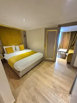 a bedroom with a large bed with yellow pillows at Taksim La Marino Hotel in Istanbul