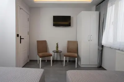 a bedroom with two chairs and a table and a tv at Carvan HOTEL in Istanbul