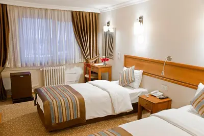 a hotel room with two beds and a window at Avlonya Hotel in Istanbul