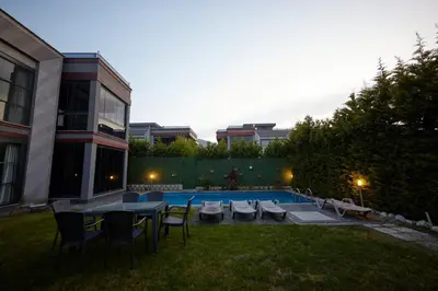 a backyard with a table and chairs and a pool at Andalus Villas NO ALCOHOL ALLOWED with Heated Pool in Sapanca