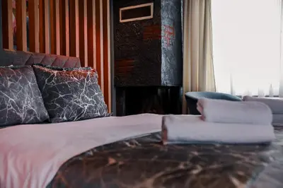 a bedroom with a bed and a chair and a fireplace at Adess Otel in Çekmeköy