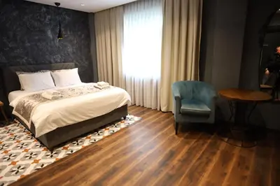 a bedroom with a bed and a chair and a table at Adess Otel in Çekmeköy