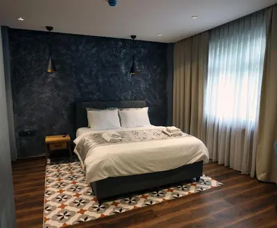 a bedroom with a bed and a blue wall at Adess Otel in Çekmeköy